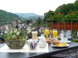 特里费尔斯山麓安韦勒Pension Bergterrasse的阳台上的桌子上摆放着食物和饮料