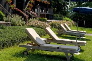 法克湖应赛尔伐科尔湖酒店的草地上设有三把躺椅和一把遮阳伞