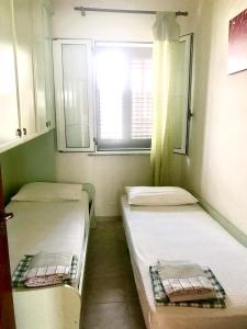 莱乌卡Villetta Wisteria的小型客房 - 带2张床和窗户