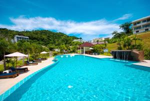 芭东海滩PS Hill Resort Phuket Patong - SHA Plus的一个带椅子和瀑布的度假村游泳池