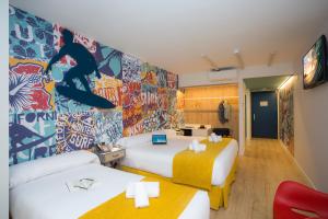 圣塞瓦斯蒂安Casual de las Olas San Sebastián的酒店客房带两张床,墙上涂有涂鸦。