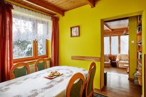 拉布卡Drewniany Dom Rabka Zdrój的一间设有桌子和黄色墙壁的餐厅