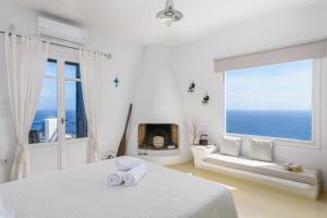 Agia Kiriaki BeachHeavenly Milos suites的白色的客房设有床和大窗户