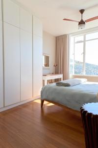 开普敦Breathtaking views, brand new renovated apartment的白色的卧室设有床和窗户