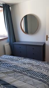 勒蒙多尔Kiruna的卧室配有一张壁挂镜子的床