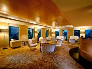 雅加达JS鲁旺萨会议中心酒店的酒店大堂设有桌椅和窗户。