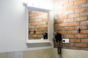 卡托维兹Apartamenty Madera的浴室设有镜子和砖墙