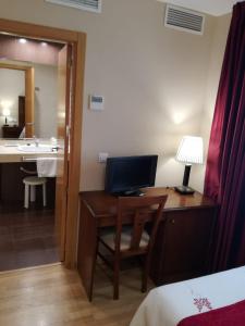 乌贝达Hotel Arcco Ubeda的酒店客房设有一张书桌和一台电脑
