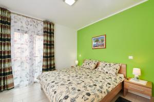 乌马格Apartman Leon的一间卧室设有一张床和绿色的墙壁