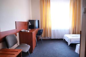 华沙朱利安诺酒店的配有电视、床和书桌的酒店客房