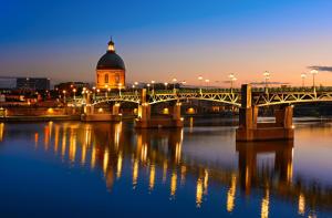 图卢兹TOULOUSE DUPLEX PLACE DU CAPITOLE的一座河上的桥梁,有一座建筑的背景