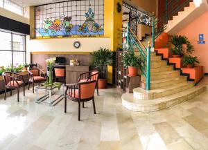 安巴托Hotel De Las Flores的大堂设有楼梯和桌椅