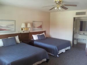 博尔德城El Rancho Boulder Motel的酒店客房配有两张床和吊扇。