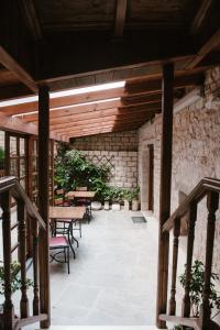 约阿尼纳肯翠康酒店的一个带桌椅的庭院和石墙