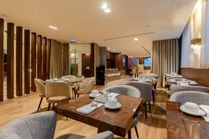 里斯本TURIM Boulevard Hotel的一间带桌椅的餐厅和一间用餐室