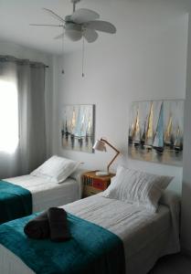 桑卢卡尔-德巴拉梅达Apartamento la albariza.的一间卧室配有两张床和吊扇