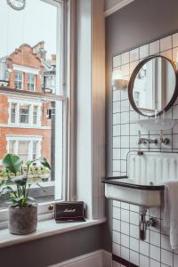 伦敦朝圣者酒店的一间带水槽和窗户的浴室