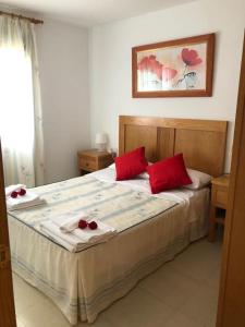 托雷德尔马尔Apartamento MILA的一间卧室配有一张带红色枕头的大床