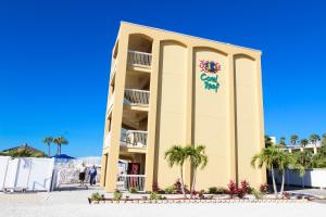 圣徒皮特海滩珊瑚礁度假酒店，VRI度假村的黄色的建筑,上面有标志