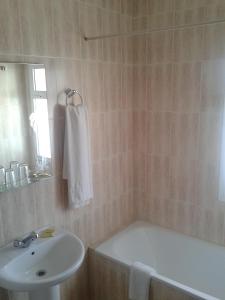 Estepona欧罗巴旅馆的浴室配有盥洗盆、浴缸和盥洗盆