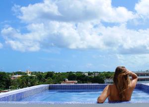 科苏梅尔Hotel Pal Cozumel的坐在游泳池边缘的女人