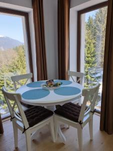 普雷代亚尔Nature House Predeal的一张白色的桌子和椅子,配有桌子和窗户