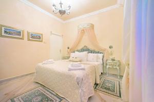 维罗纳Fiore d'arancio Luxury City Center Apartment的一间卧室配有一张带天蓬的白色床