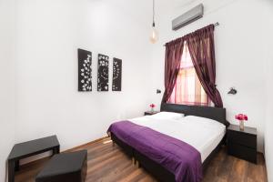 布达佩斯卡玛精品公寓酒店的一间卧室设有紫色的床和窗户