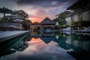 努沙杜瓦REVĪVŌ Wellness Resort Nusa Dua Bali的一个带凉亭的游泳池,享有日落美景