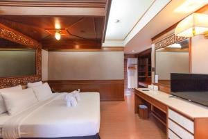 清迈Holiday Garden Hotel & Resort SHA EXTRA PLUS的卧室配有白色的床和平面电视。