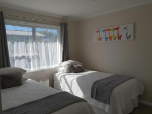 罗托鲁瓦Rose Apartments Unit 5 Central Rotorua- Accommodation & Spa的一间卧室设有两张靠窗的床。