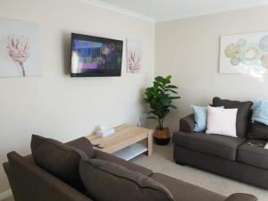 罗托鲁瓦Rose Apartments Unit 5 Central Rotorua- Accommodation & Spa的客厅配有沙发和桌子