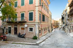 科孚镇La vecchia bottega del Nonno - Corfu的停在大楼旁边的一条带摩托车的小巷