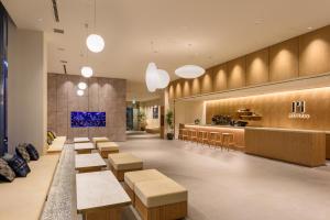 东京hotel MONday Premium TOYOSU的一个带长椅和柜台的餐厅的大堂