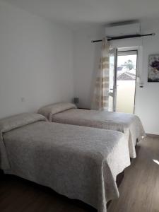 贝纳尔马德纳贝纳尔海滩茉莉公寓的白色客房的两张床,设有窗户