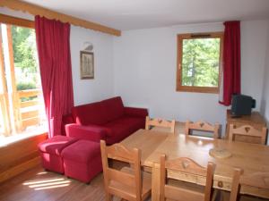 瓦尔L'Ecrin des Neiges的客厅配有红色的沙发和桌子