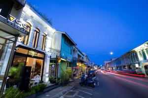 普吉镇Xinlor House - Phuket Old Town的街道上拥有建筑和摩托车的城市街道