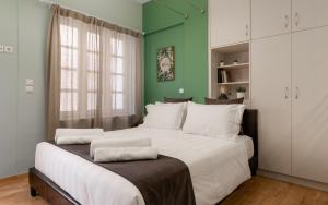 雅典Monastiraki Urban Apartments的一间卧室设有一张白色大床和绿色的墙壁