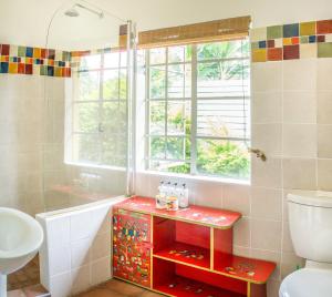 哈拉雷Jacana Gardens的一间带水槽和卫生间的浴室以及窗户。