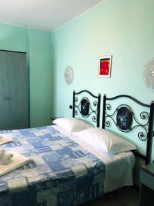 皮尼奥内Antiche Terre Hotel & Relax的一间卧室配有一张蓝色墙壁的床