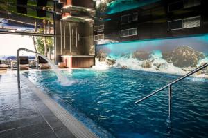 尤斯托尼莫斯基Max Health Resort SPA的一座大楼内带水滑梯的游泳池