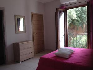 贡内萨Ampio appartamento Sulcis Iglesiente Sardegna的卧室配有粉红色的床和窗户。