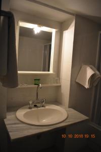 罗希姆诺Vecchio Hotel的浴室配有带镜子的盥洗盆和镜子