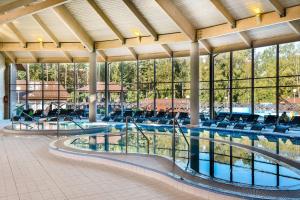 帕兰加Atostogų Parkas Hotel的大楼内带椅子的大型游泳池