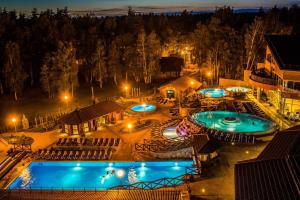 帕兰加Atostogų Parkas Hotel的两个泳池的夜间景色