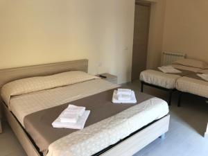 卡尔塔尼塞塔B&B Trieste Caltanissetta的客房内的两张床和毛巾