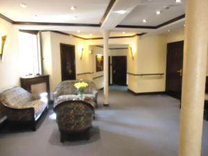 萨勒河畔哈雷玛莎酒店的客厅配有两把椅子和一张沙发