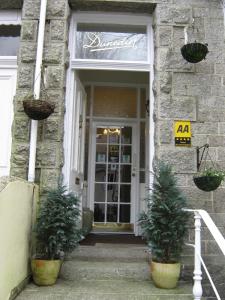 彭赞斯顿恩丁旅馆的两棵盆栽植物的建筑物的前门