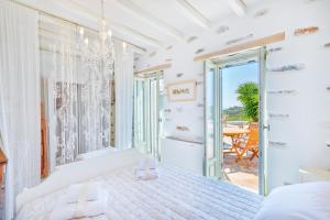梅加斯·亚洛斯-奈特斯MEGAS GIALOS HARMONY的一间白色卧室,配有床和阳台