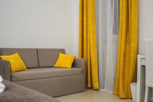 格拉维纳普利亚LA CIVITA B&B的客厅里一张带黄色窗帘的沙发